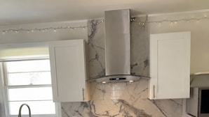 A kitchen with a built-in stove, a sink, and cabinets. - Emerald Retreat - Modern 3 Bedroom Near Atlanta (Austell)