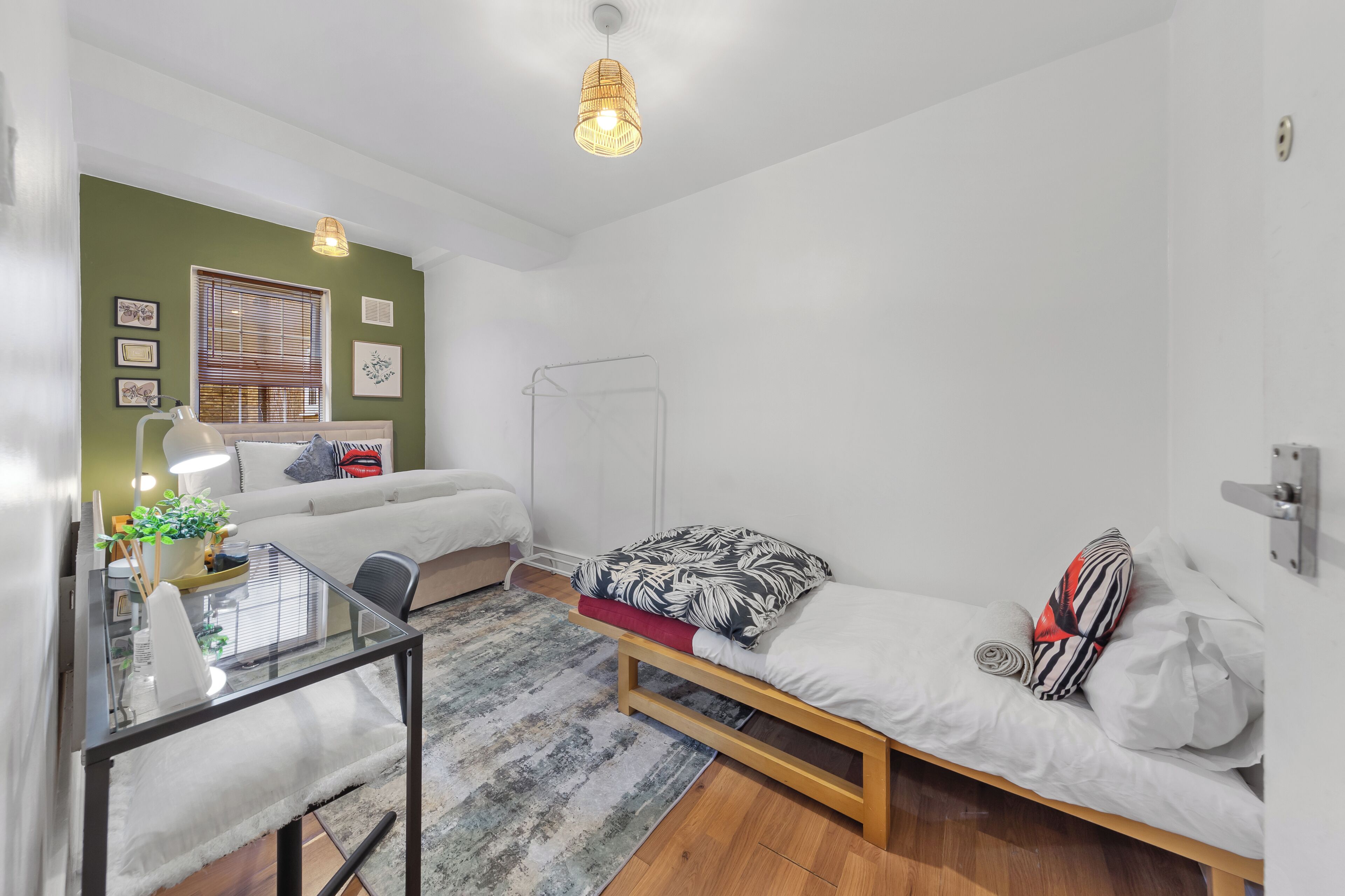 A compact bedroom with a bed, bedside table, and a hanging light fixture.