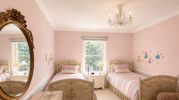 A bedroom with two beds, a dresser, a mirror, and a chandelier. - Beautiful Lakeside Home 7 Minutes from Bellerive CC (Chesterfield)