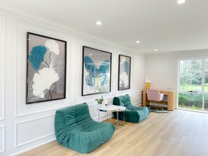 A modern living room with a sofa, a small table, and framed artwork on the wall.