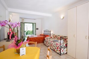 A room with a bed, a sofa, a table with a vase of flowers, and a wardrobe. - Borgo Primizia Room 3 B&B, Otranto, Italy (Otranto)