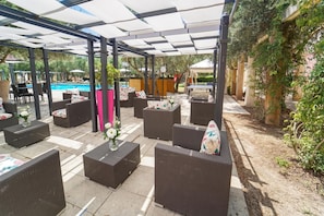 An outdoor patio area with wicker furniture, a pool, and a covered seating area. - Borgo Primizia Room 2 B&B, Otranto, Italy (Otranto)