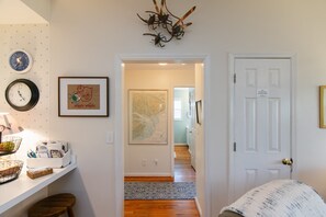Un pasillo con una puerta blanca, un mapa y una decoración con forma de alcancía.