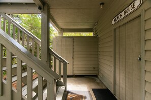 Eine überdachte Veranda, die zu einer Garage führt, mit einem Schild 'Beach House'.