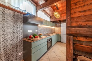 A modern kitchen with a tiled backsplash, wooden beams, and a built-in oven. - Casa di Adriana&Claudia, Porto Cesareo, Italy (Porto Cesareo)