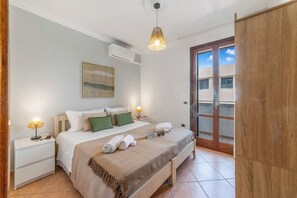 A hotel room with a bed, bedside tables, a lamp, a wall art piece, and a view of the outside through a door. - Casa di Adriana&Claudia, Porto Cesareo, Italy (Porto Cesareo)