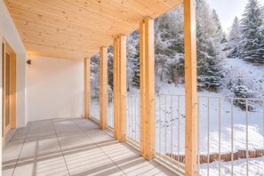 A covered outdoor area with wooden beams and a metal railing, overlooking a snowy landscape. - Residenza Castanea 306 San Bernardino Alpine Apartments, San Bernardino, Switzerland (San Bernardino)