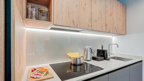 Eine moderne Küche mit Einbauherd, Spüle und Holzausstattung.
