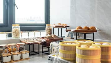 Un bufé de desayuno con diversas opciones de comida y una máquina de café.