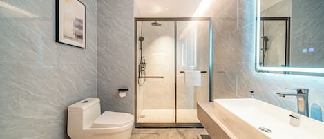 A modern bathroom with a toilet, shower, and bathtub.