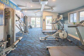 Academia com máquinas de cardio, equipamentos de musculação e esteira.