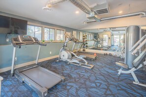 Een sportschool met loopbanden, elliptische trainers en gewichten.