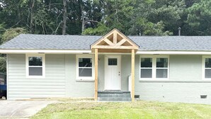 A single-story house with a front porch, a door, and two windows on the side. - Enjoyable 4-bedroom house with AC in charming Atlanta (Atlanta)