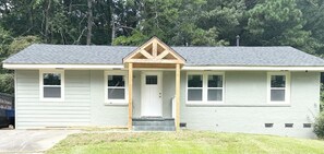 A single-story house with a front porch, a door, and two windows on the side. - Enjoyable 4-bedroom house with AC in charming Atlanta (Atlanta)