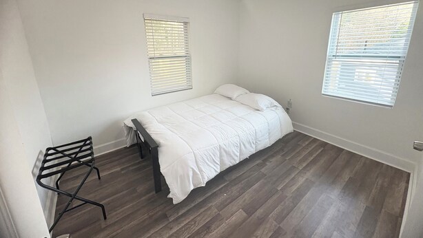 A bedroom with a bed, a chair, and two windows with blinds. - Enjoyable 4-bedroom house with AC in charming Atlanta (Atlanta)