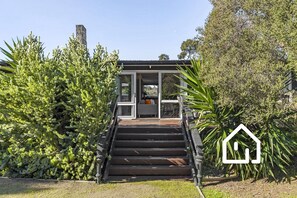 Ein modernes Haus mit einer Treppe, die zu einer Glastür führt.