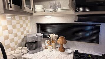 A modern kitchen with a built-in microwave, stainless steel sink, and a gas stove.