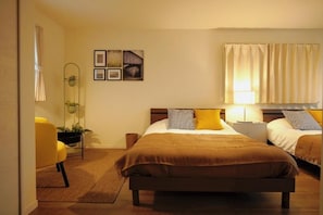 A bedroom with a large bed, two bedside tables, a chair, and a wall-mounted mirror. - ANNKICHI (Nishinari Ward,Osaka)