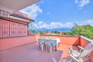 A terrace with a table set for two, chairs, and a view of the surrounding landscape. - Manuela's Apartment Stresa next to center Lake View Terrace, Stresa, Italy (Stresa)