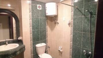 A bathroom with a toilet, sink, and shower area.