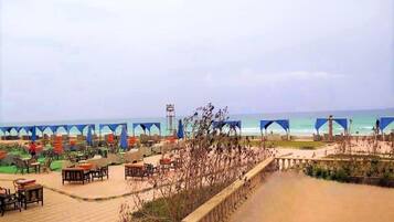 A beachside area with outdoor seating and a view of the ocean.