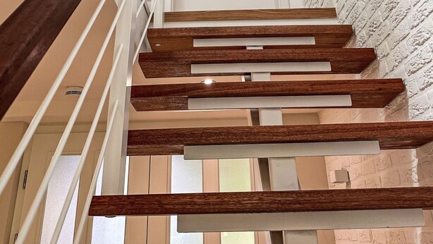 A staircase with wooden handrails and a white door at the top. - The OAK SUITE by Interhome (Bad Bederkesa)
