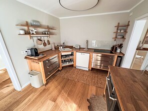 A compact kitchen with wooden countertops, a built-in dishwasher, and a small sink. - The OAK SUITE by Interhome (Bad Bederkesa)