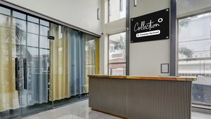 A reception desk with a sign above it, a glass door with curtains, and a patterned floor. - Collection O B.R. AmbedkarParkTaramandal (Gorakhpur)