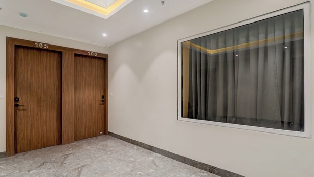 A hallway with two wooden doors labeled 105 and 106, a large window with curtains, and a marble floor. - Collection O B.R. AmbedkarParkTaramandal (Gorakhpur)