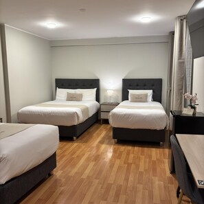 A hotel room with two beds, a desk, and a nightstand. - Inkalma Centro (Arequipa)