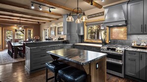 A modern kitchen with a large island, built-in appliances, and a rustic ceiling. - Whitefish Lake Waterfront Retreat W/ Private Dock (Whitefish)