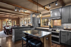 A modern kitchen with a large island, built-in appliances, and a rustic ceiling. - Whitefish Lake Waterfront Retreat W/ Private Dock (Whitefish)