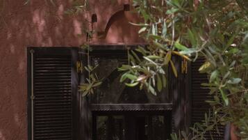 A window with a view of a garden, a door, and a small balcony area.