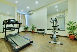 Una sala de gimnàstica amb cinta de córrer, el·líptica i banc de peses.