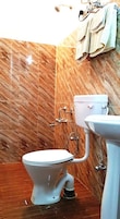 Un baño con inodoro, lavabo y paredes de mármol.