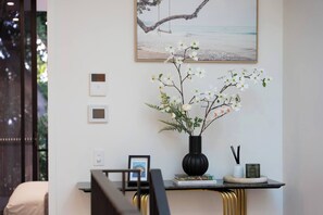 Ein Zimmer mit Schreibtisch, einer Blumenvase, einem gerahmten Bild und einem Buch mit dem Titel 'MALLORCA & IBIZA'.