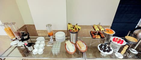 A buffet table with various food items and beverages.