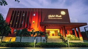 Un edificio moderno con una entrada destacada, un letrero que dice 'Gulab Kothi Boutique Hotel & Banquets' y una fachada bien iluminada.