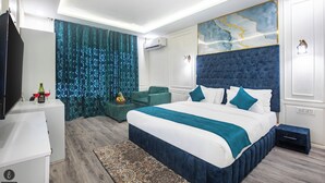 A modern bedroom with a large bed, a television, and a decorative wall piece. - Classy Castle (Anantnag)