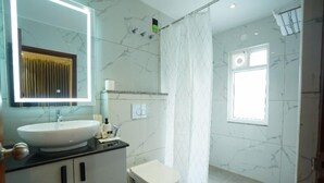Un baño con un lavamanos blanco, un inodoro, un espejo y una cortina de ducha.