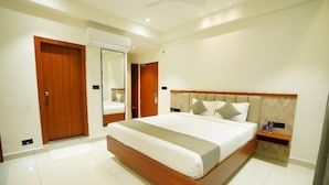 Habitación de hotel con una cama grande, un cabecero de madera, una mesita de noche y un armario.