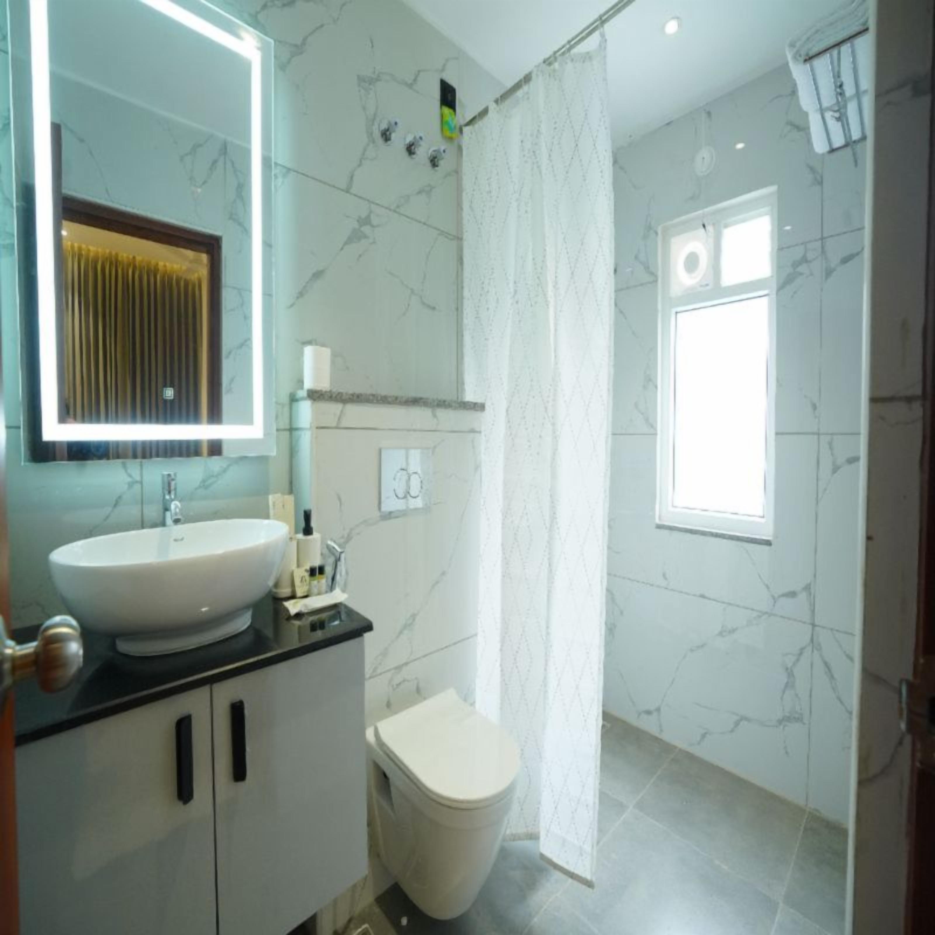 A bathroom with a sink, toilet, and shower curtain.