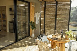 A modern outdoor dining area with wicker furniture, a table set for two, and a view of the surrounding landscape. - La Pausa Hotelbistro (San Luis)