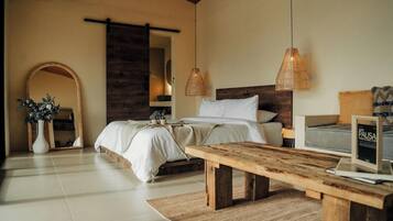 Un dormitorio con una cama, una mesita de noche y un banco de madera.