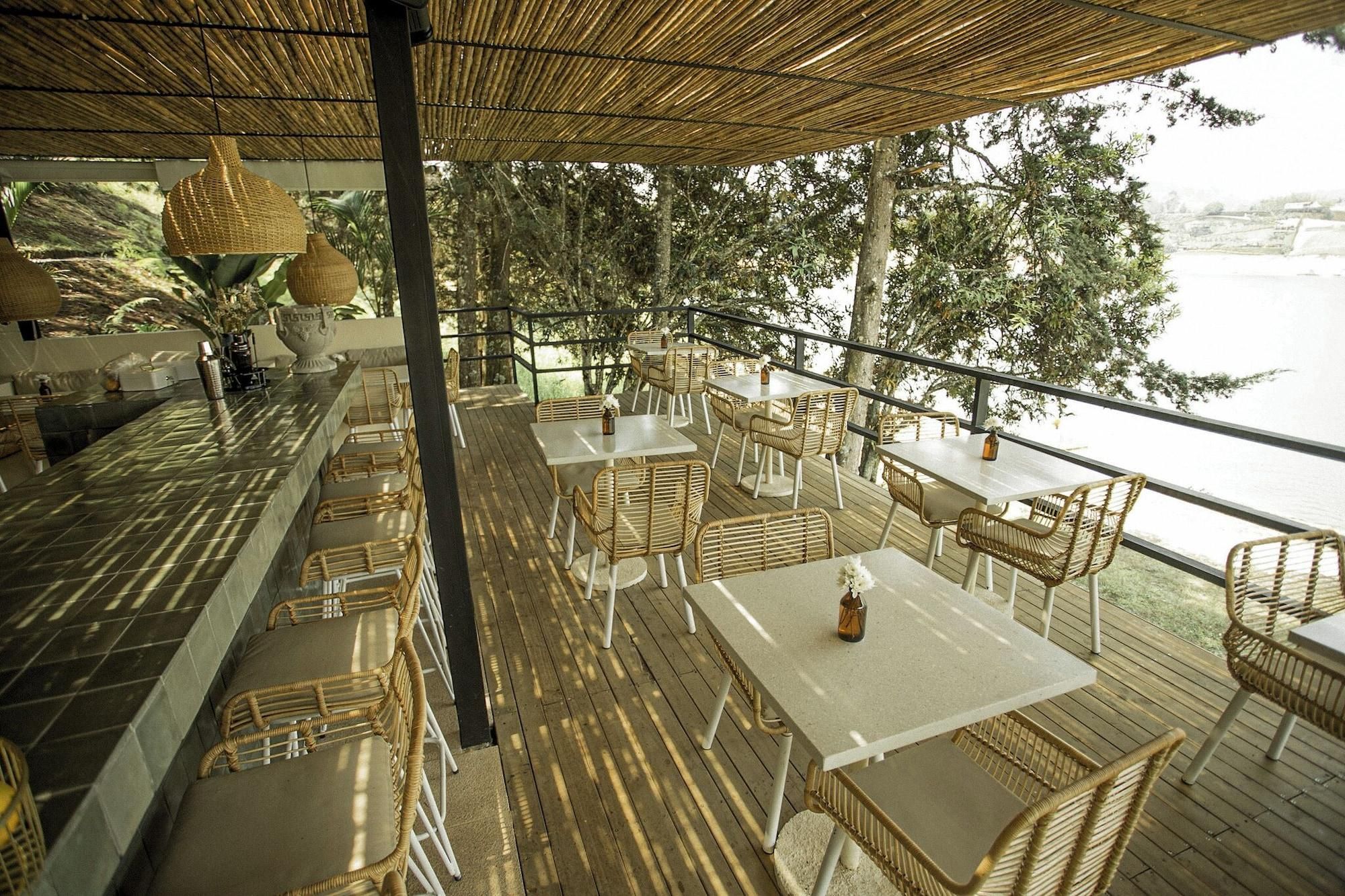 Un área de comedor al aire libre con mobiliario de mimbre y vistas al agua.