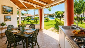 En uteservering med utsikt över en pool och en trädgård.