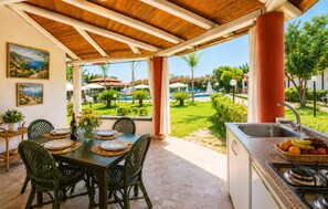 An outdoor dining area with a view of a pool and garden. - Nice home in Nicotera Marina (Nicotera Marina)