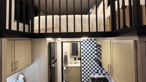 Een kleine keuken met een zwart-wit betegelde achterwand, een spoelbak en een fornuis.