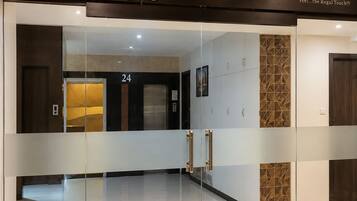 L’entrée du palais Regaal est marquée par une porte en verre, une enseigne au-dessus indiquant « Palais Regaal », et le numéro « 24 » est visible à l’intérieur.