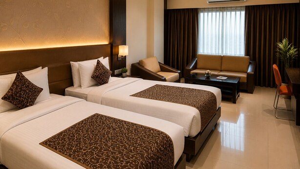 A hotel room with two beds, a sofa, a desk, and a chair. - The Regaal - 5 mins from Railway Station (Jalgaon)